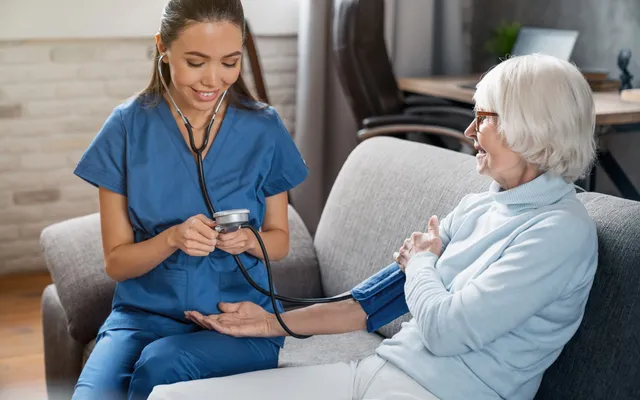Nurse checking an older patient’s blood pressure at home
