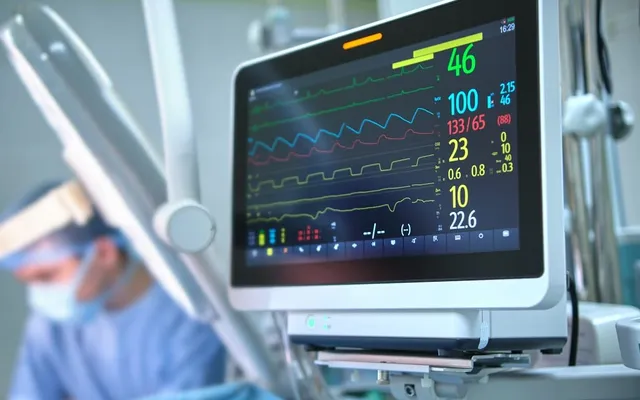 Patient condition monitor beside a clinician in an operating room